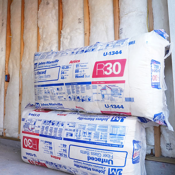 two packages of wall insulation against a bare wall